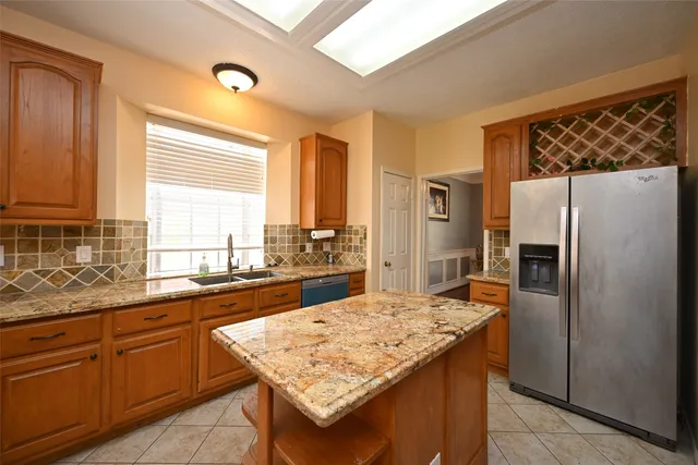 a kitchen with stainless steel appliances granite countertop a refrigerator a sink and a stove