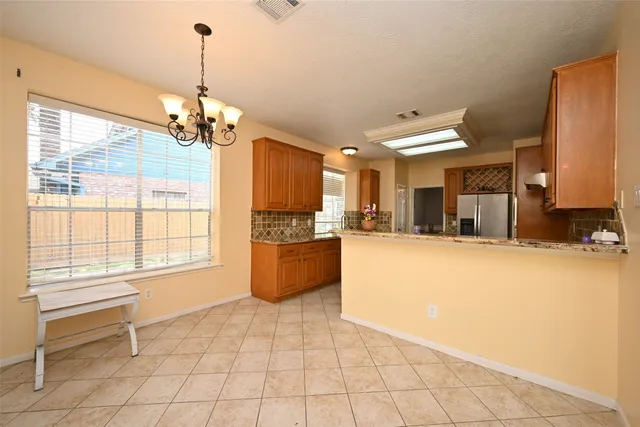 a view of open kitchen with granite countertop cabinets and a table