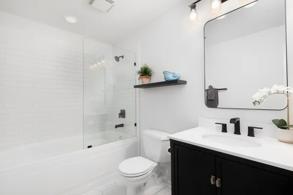 a bathroom with a sink a toilet and shower