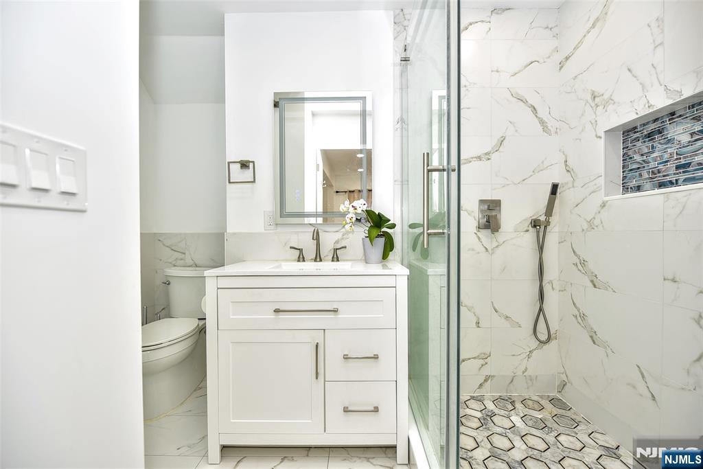 111 Teaneck Road Teaneck, NJ 07666 - Photo 9 of 22 a bathroom with a shower sink and mirror