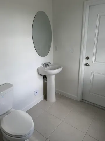 a bathroom with a sink toilet and a mirror