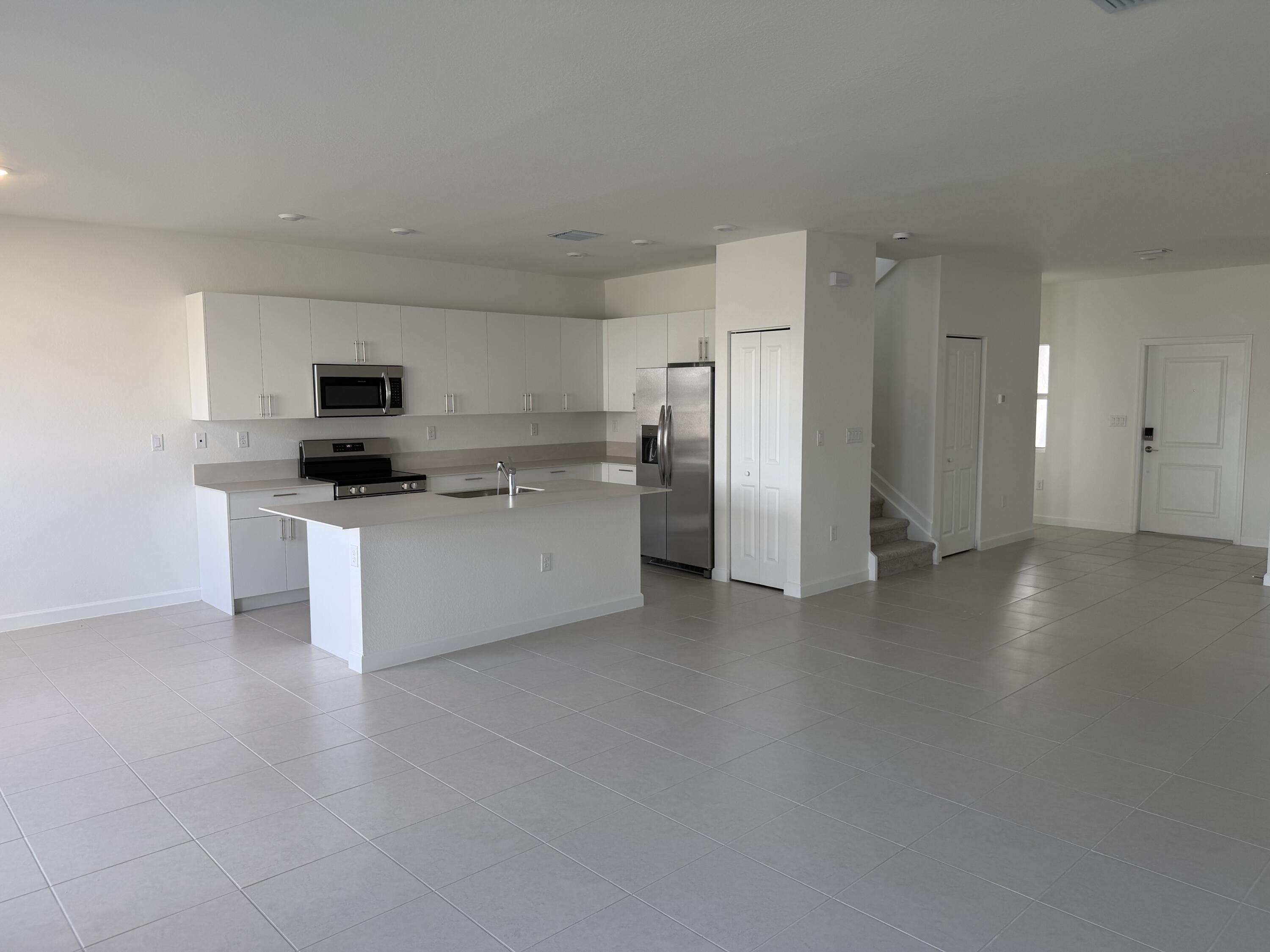 19407 Southwest 340th Street Homestead, FL 33034 - Photo 4 of 15 a kitchen with stainless steel appliances a refrigerator a stove a sink and white cabinets