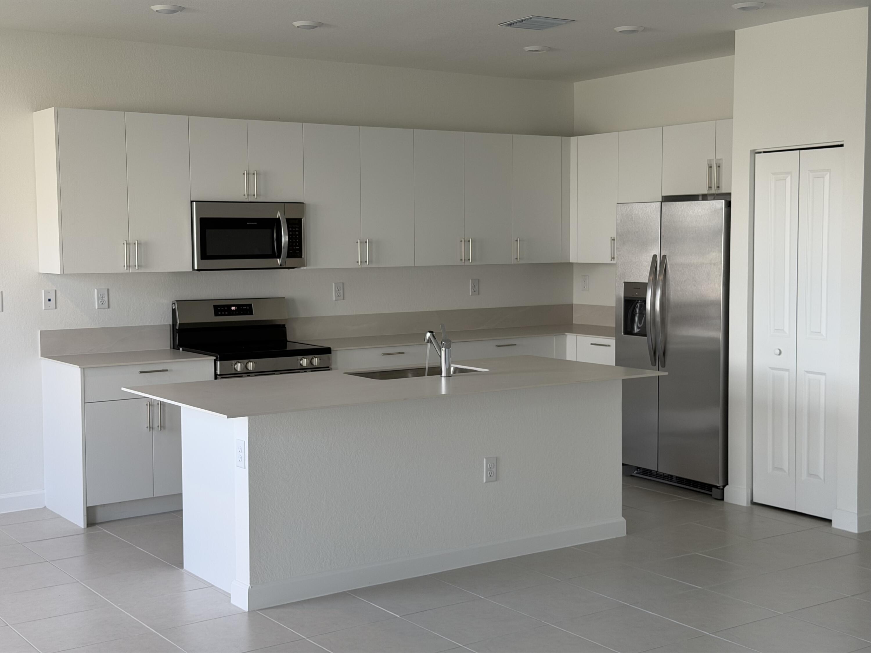 19407 Southwest 340th Street Homestead, FL 33034 - Photo 5 of 15 a kitchen with stainless steel appliances granite countertop a refrigerator a stove a sink and a microwave