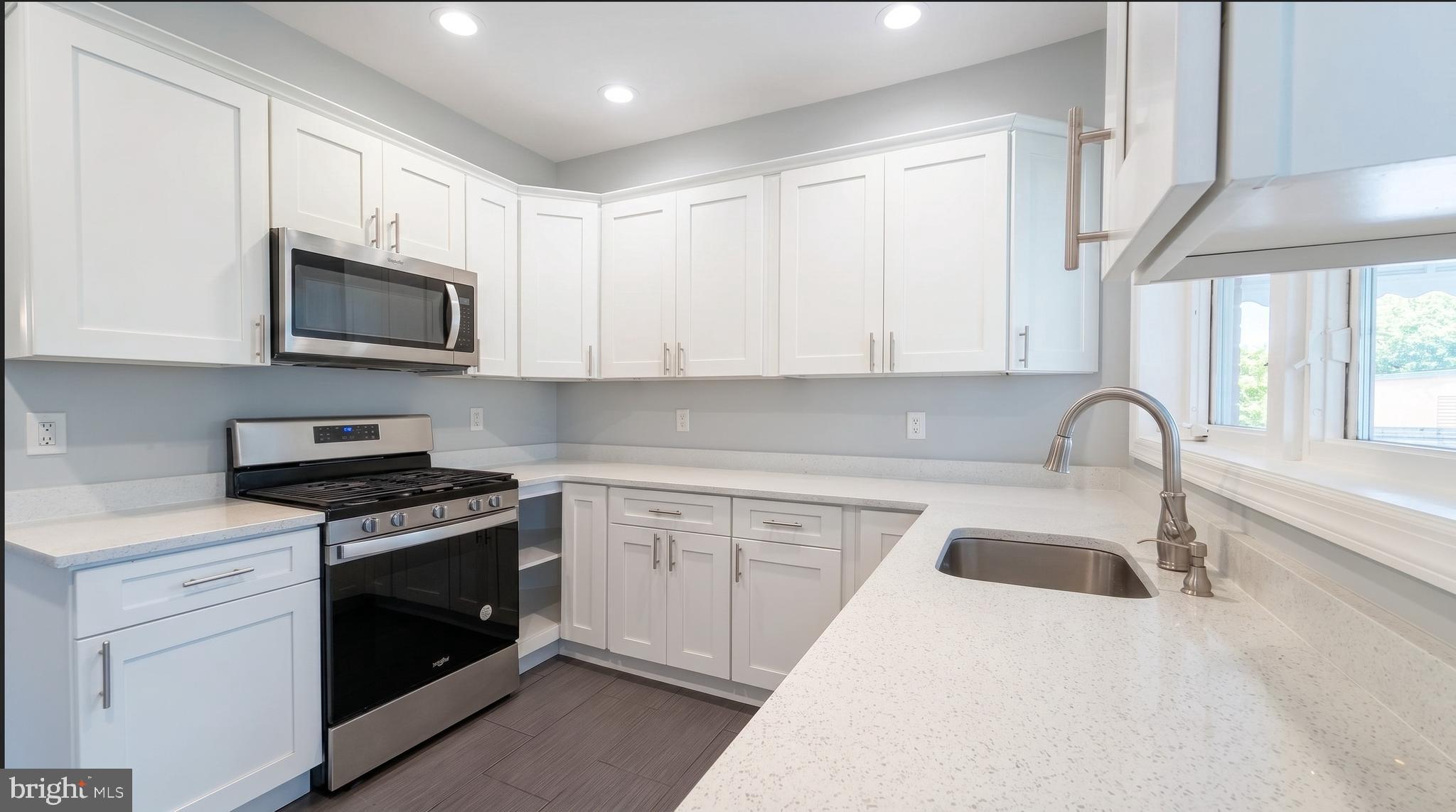 154 Andrew Street Hamilton, NJ 08610 - Photo 10 of 29 a kitchen with granite countertop white cabinets and stainless steel appliances