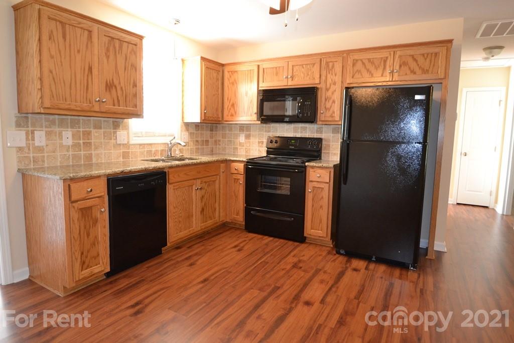 3793 Lee Moore Road, Unit 3793 Maiden, NC 28650 - Photo 3 of 11 a kitchen with stainless steel appliances granite countertop a refrigerator and a stove top oven