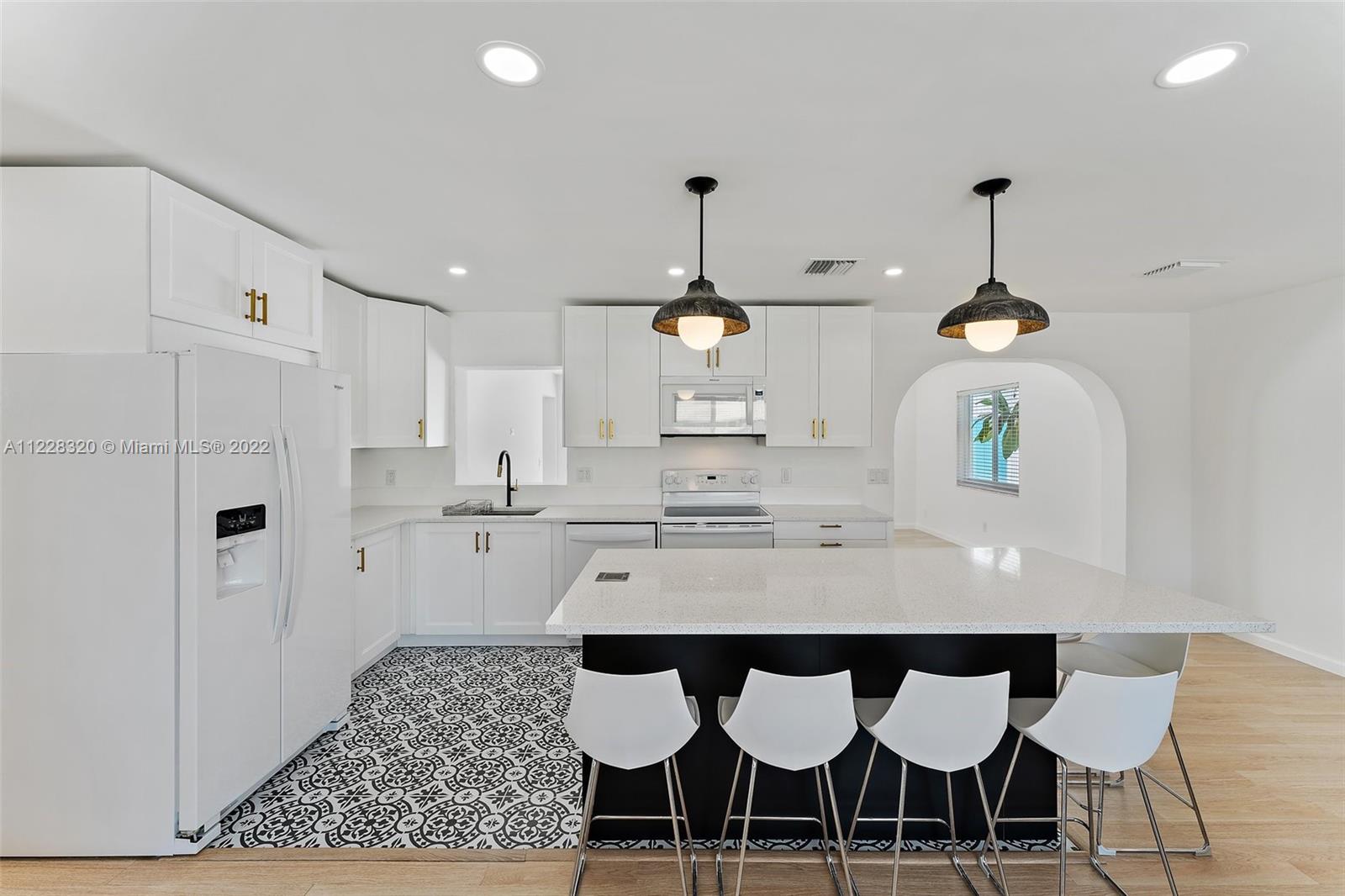 19 Shay Place Tequesta, FL 33469 - Photo 13 of 46 a kitchen with a dining table chairs stainless steel appliances and cabinets