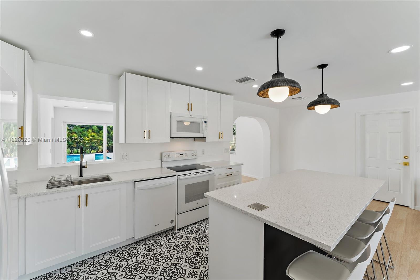 19 Shay Place Tequesta, FL 33469 - Photo 14 of 46 a kitchen with stainless steel appliances a sink a stove a refrigerator and white cabinets