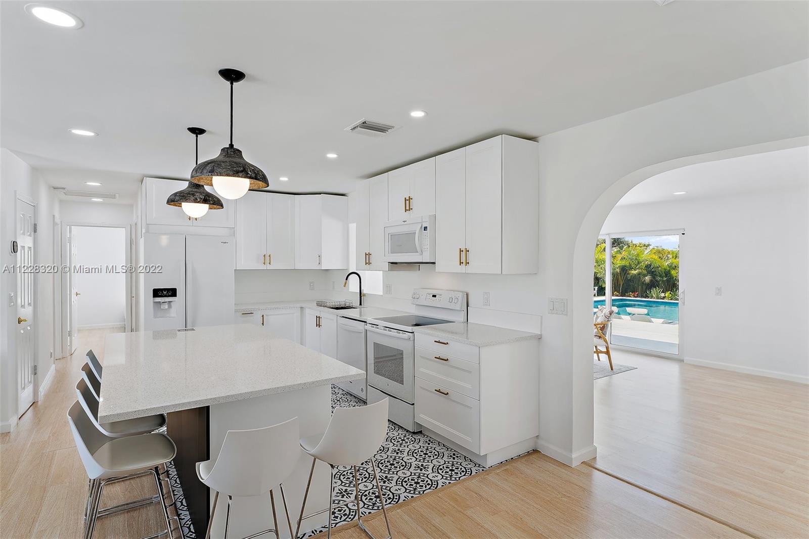 19 Shay Place Tequesta, FL 33469 - Photo 16 of 46 a kitchen with stainless steel appliances granite countertop a sink a stove a refrigerator and island with wooden floor