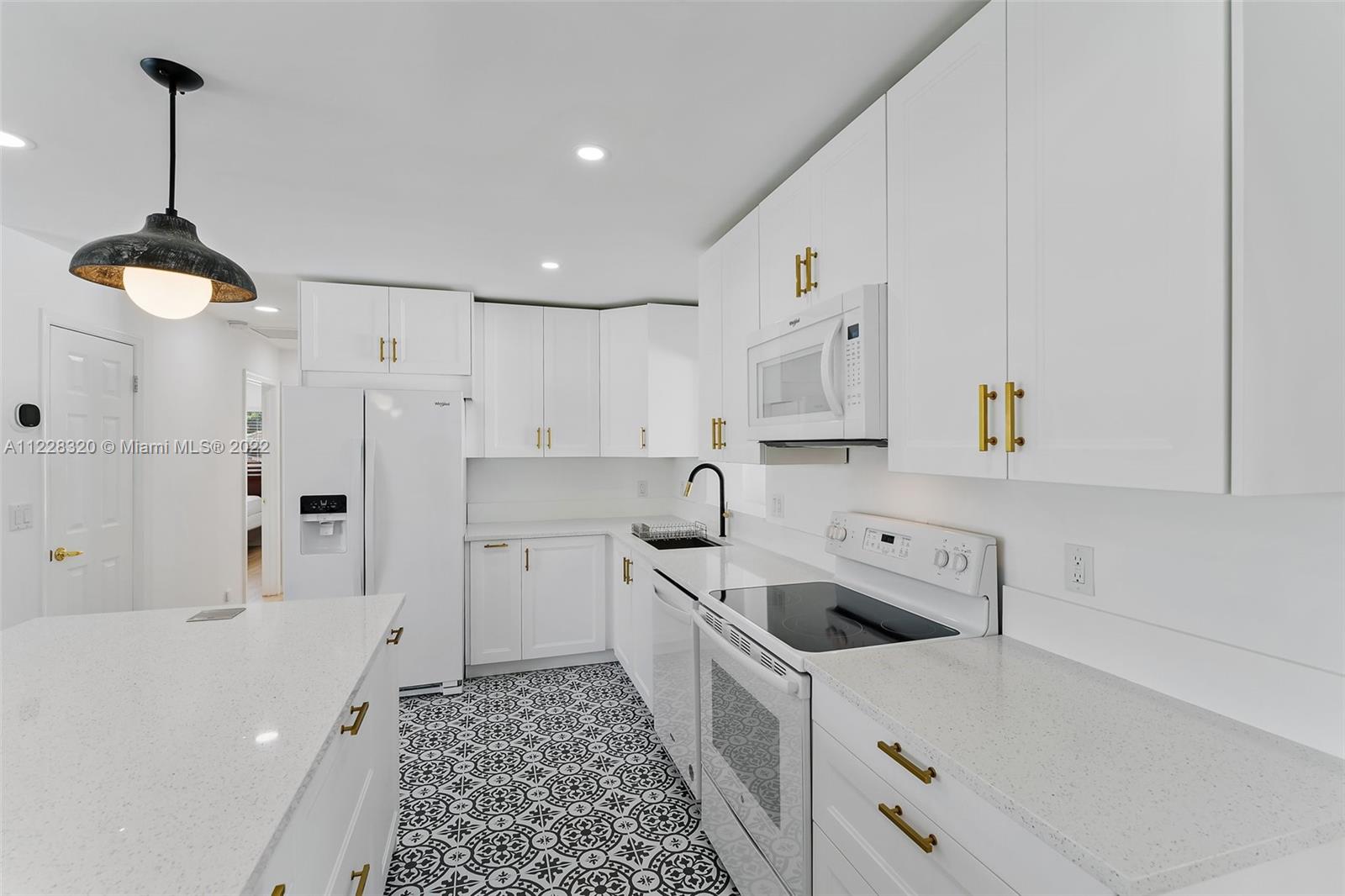 19 Shay Place Tequesta, FL 33469 - Photo 18 of 46 a kitchen that has a lot of white cabinets and stainless steel appliances