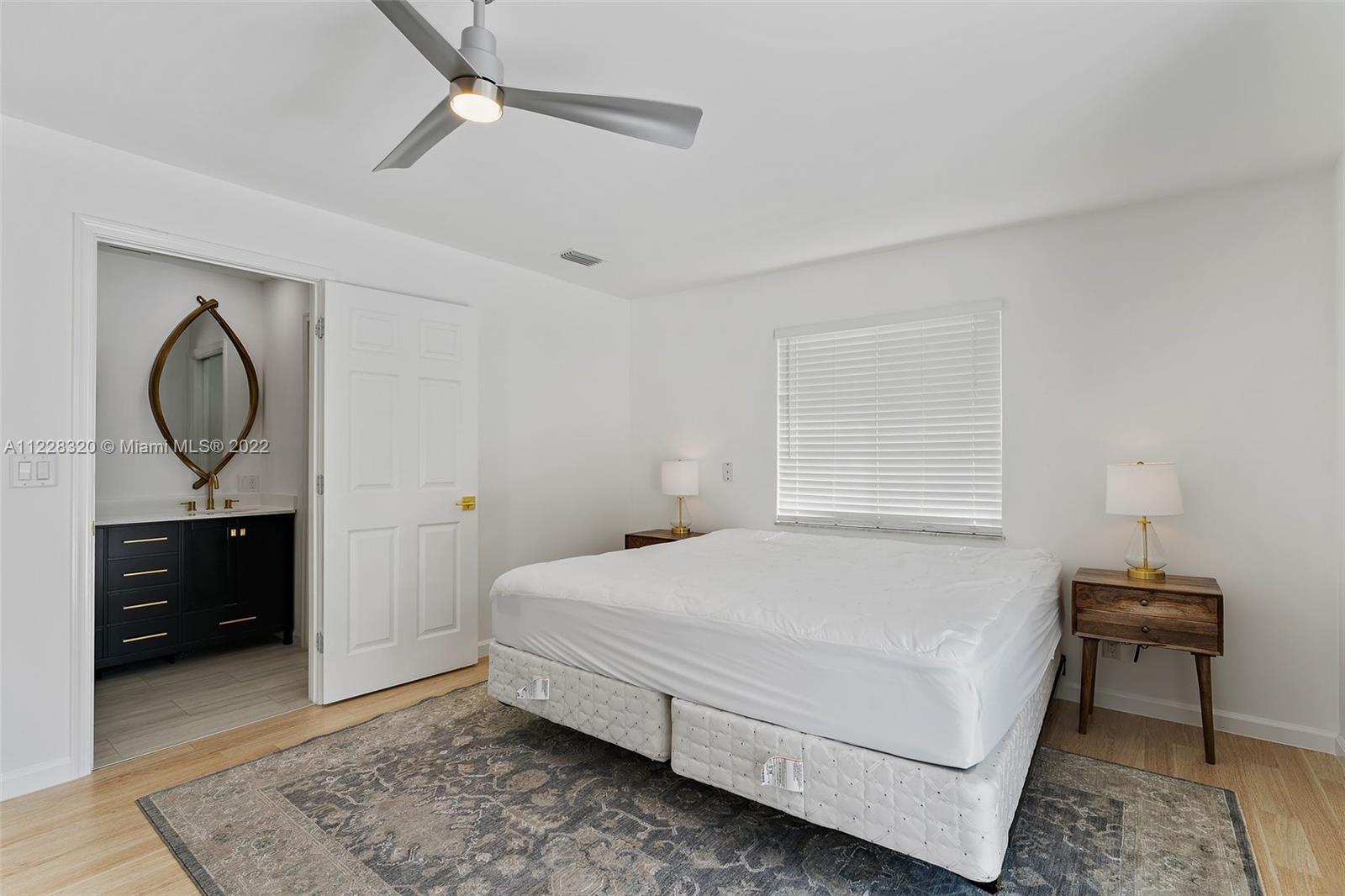 19 Shay Place Tequesta, FL 33469 - Photo 27 of 46 a bedroom with a bed and a chandelier