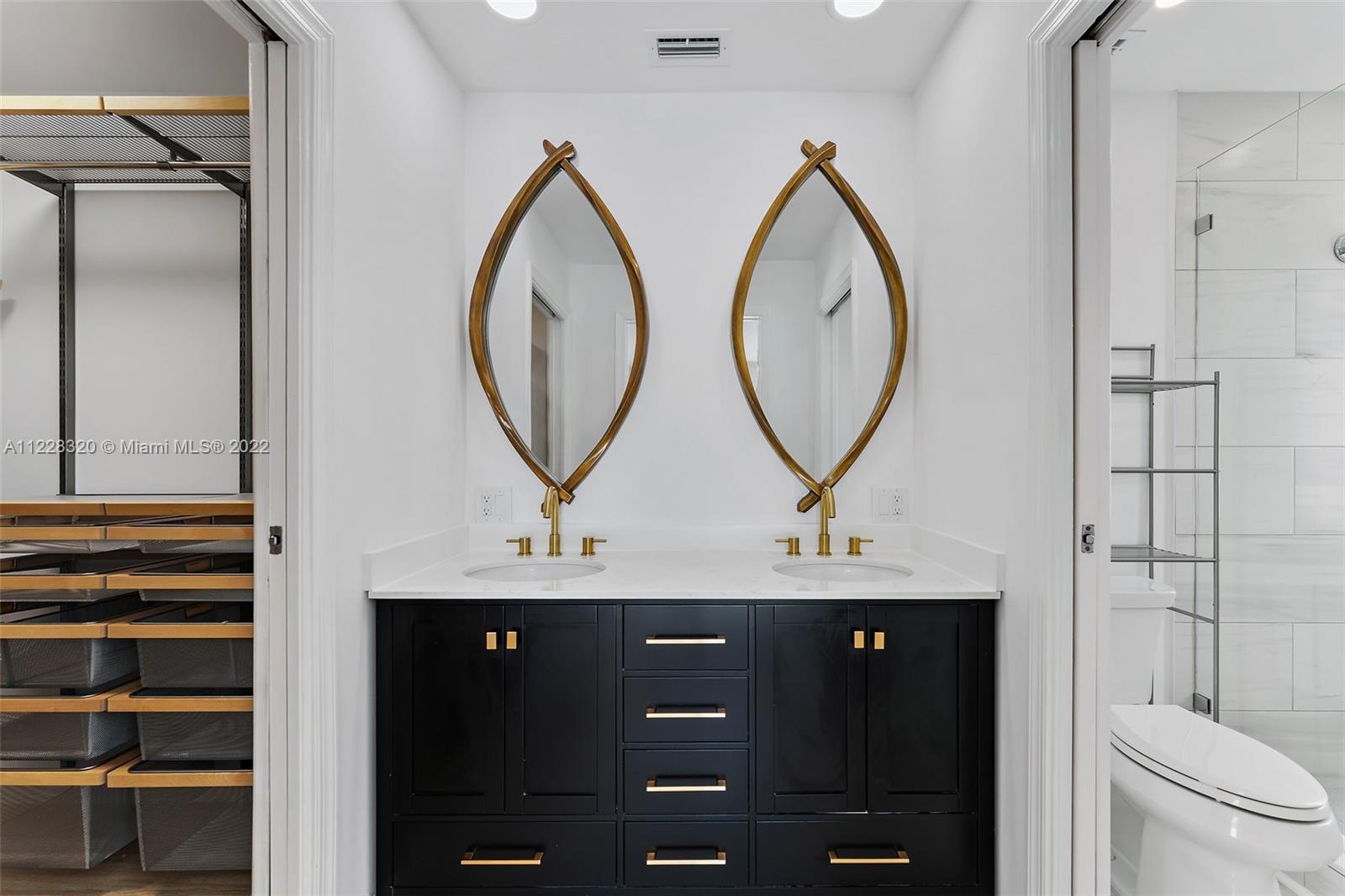 19 Shay Place Tequesta, FL 33469 - Photo 30 of 46 a bathroom with a double vanity sink and a mirror