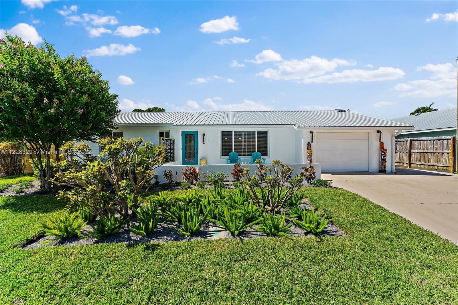 19 Shay Place Tequesta, FL 33469 - Photo 3 of 46 a front view of a house with a yard and outdoor seating