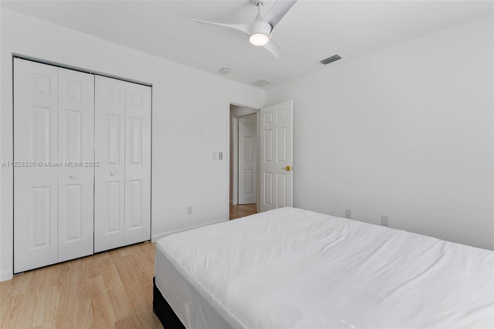 19 Shay Place Tequesta, FL 33469 - Photo 33 of 46 a bedroom with a bed and a chandelier fan