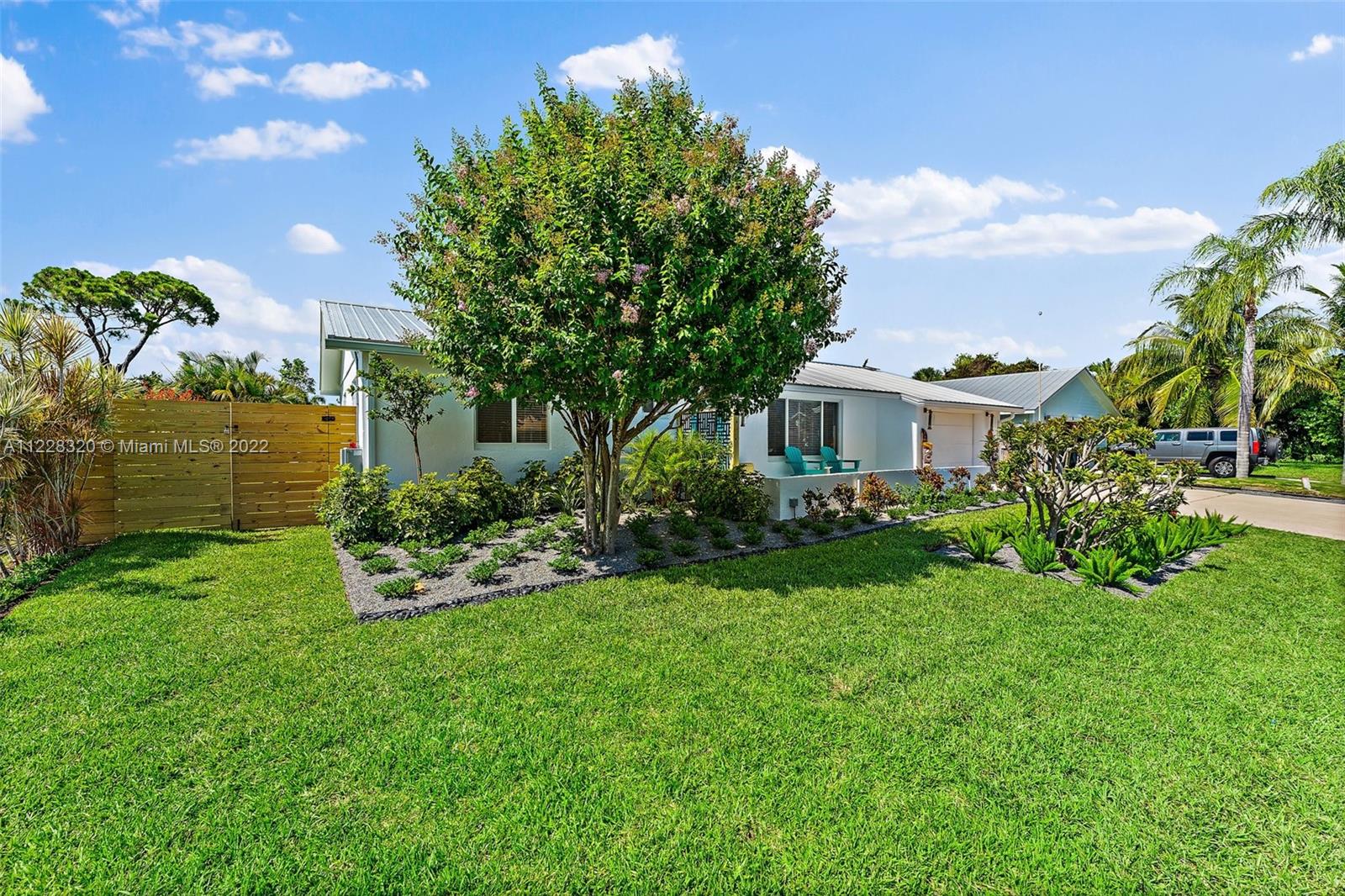 19 Shay Place Tequesta, FL 33469 - Photo 4 of 46 a front view of a house with a garden