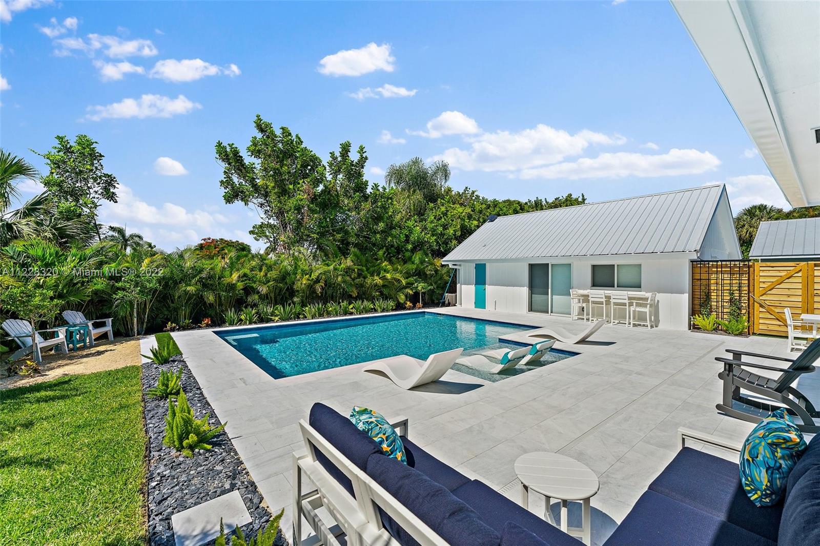 19 Shay Place Tequesta, FL 33469 - Photo 42 of 46 a view of house with patio entertaining space with furniture and a garden