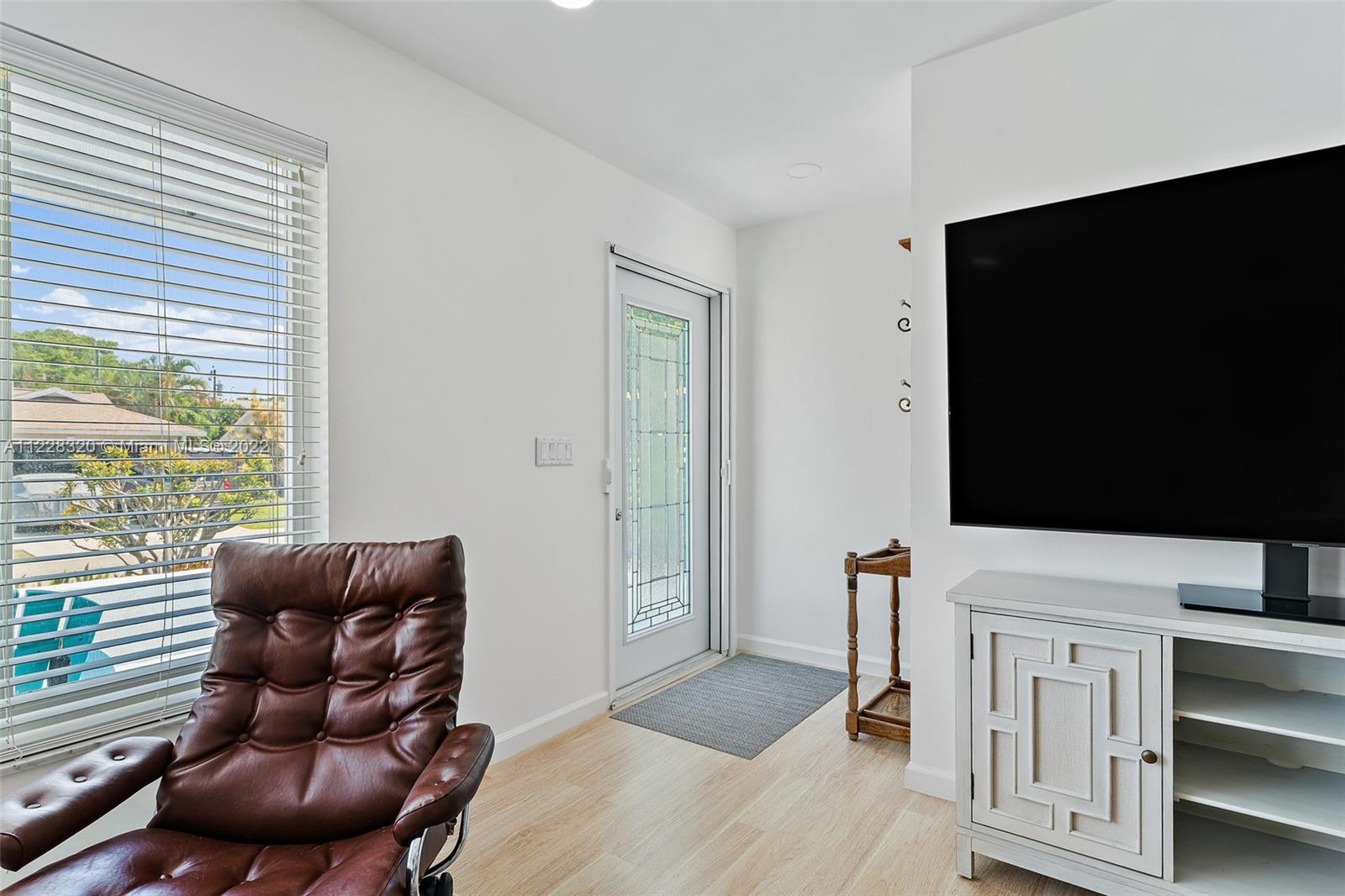 19 Shay Place Tequesta, FL 33469 - Photo 8 of 46 a living room with furniture a flat screen tv and a large window
