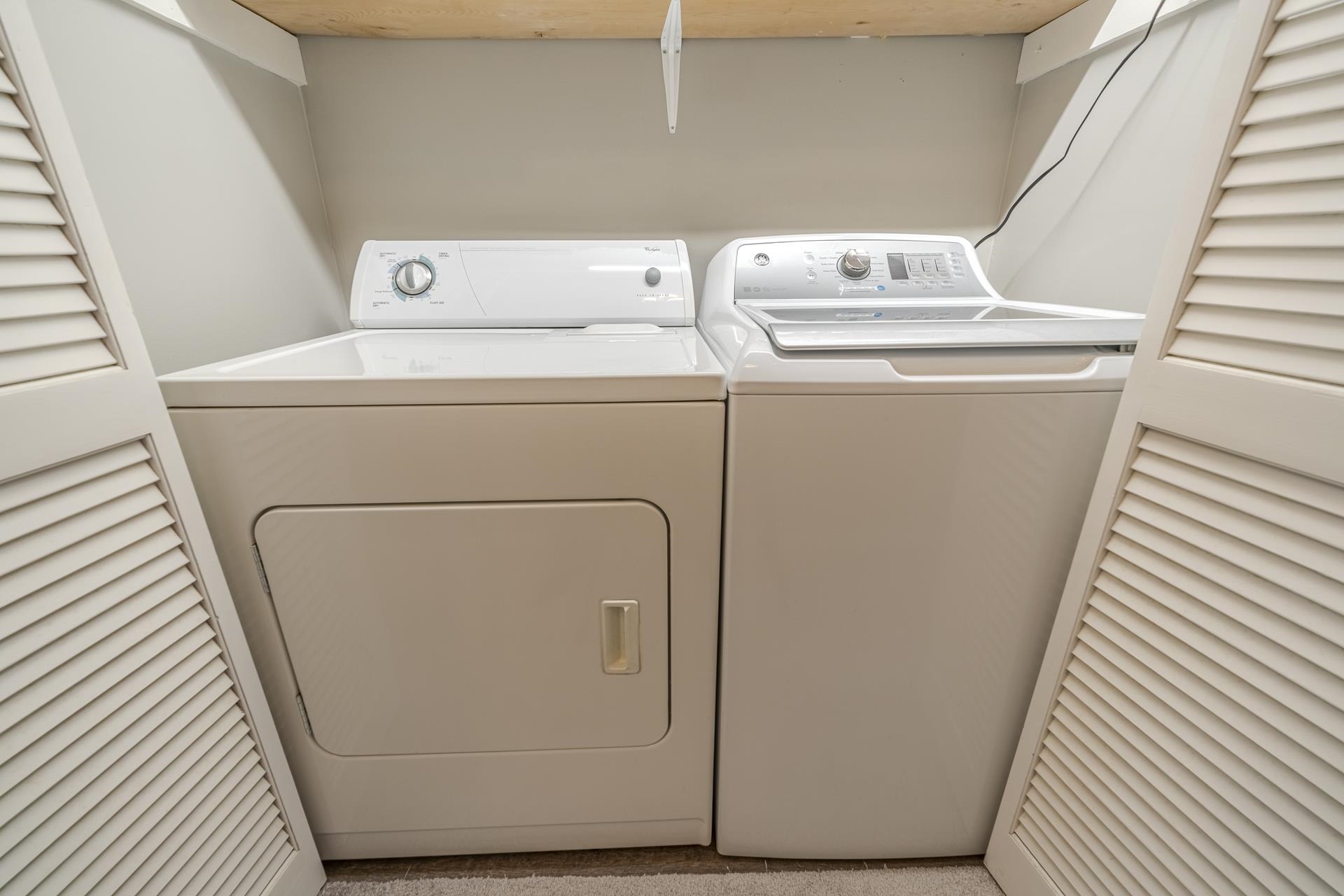 74 Driftwood Road Counce, TN 38326 - Photo 20 of 40 Dedicated laundry area featuring a white top-load washer and a white front-load dryer, enclosed by louvered bifold doors