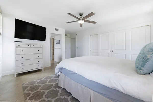 a spacious bedroom with a bed and a flat screen tv