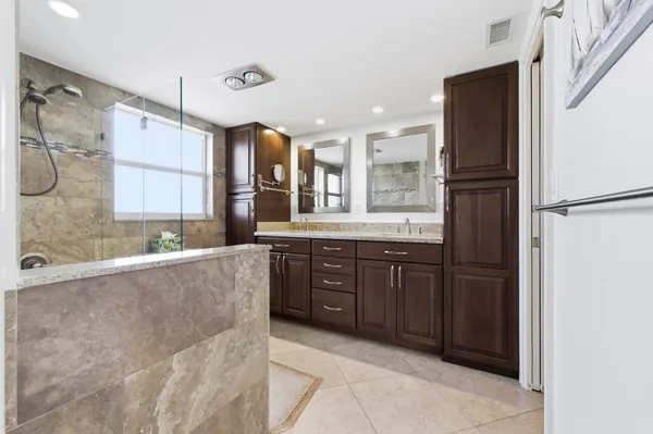 a large bathroom with a large mirror vanity and a bathtub