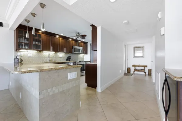 a kitchen with granite countertop a sink and a stove top oven