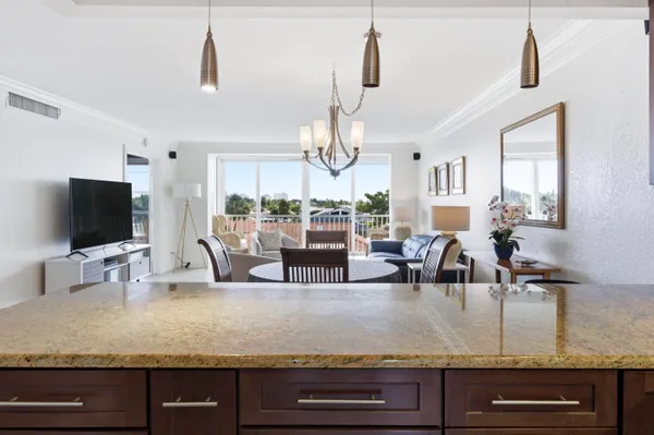 a living room with granite countertop kitchen island stainless steel appliances and a large window