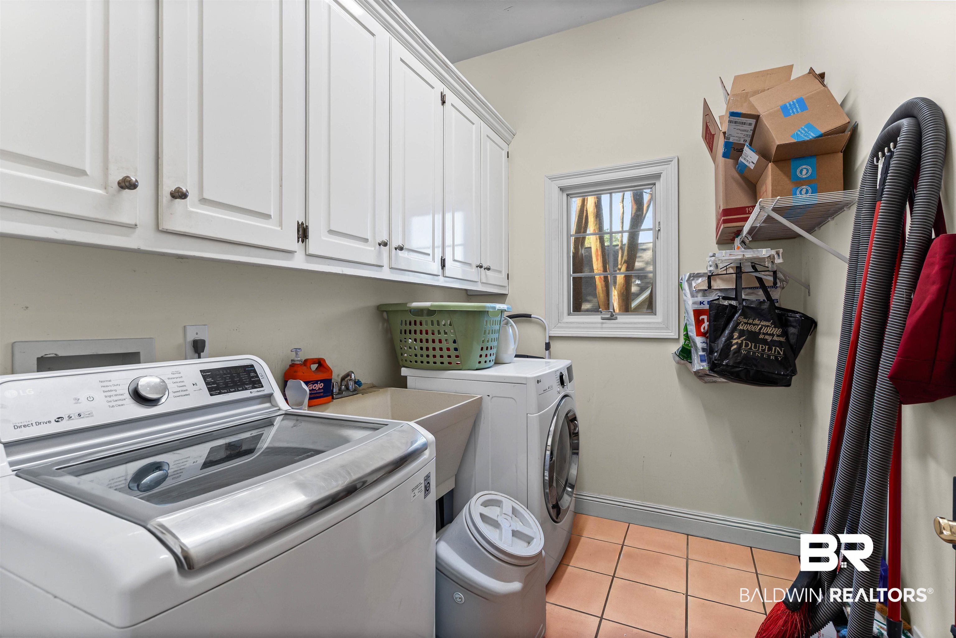 107 Beaver Dam Road Fairhope, AL 36532 - Photo 28 of 45 Laundry room featuring light tile patterned floors, cabinet space, and washing machine and dryer