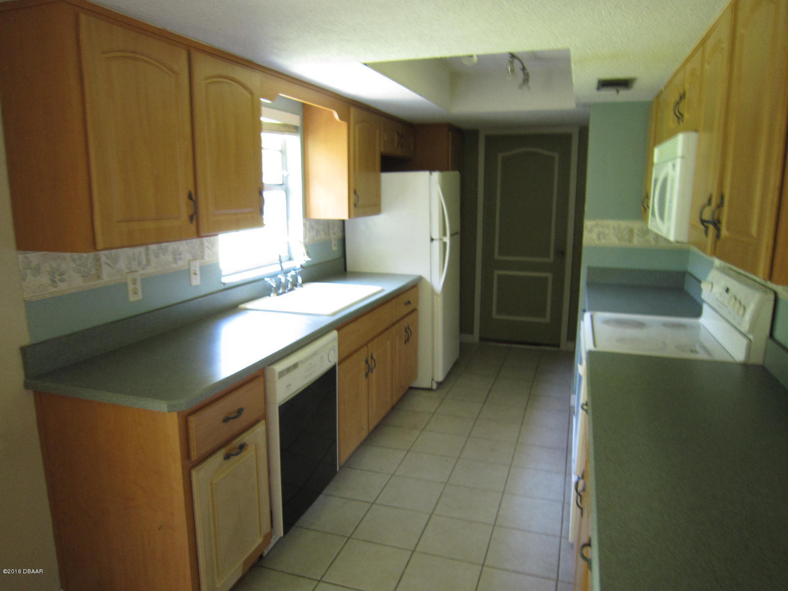 1706 Western Road South Daytona, FL 32119 - Photo 3 of 16 a kitchen with a sink a stove top oven a refrigerator and a dishwasher