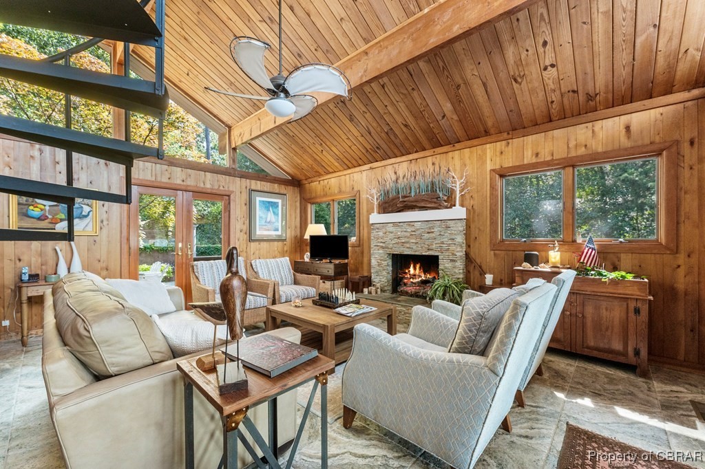 1106 Monarch Shores Road Kilmarnock, VA 22482 - Photo 7 of 44 Living room with a fireplace, wood ceiling, lofted ceiling with beams, ceiling fan, and wooden walls