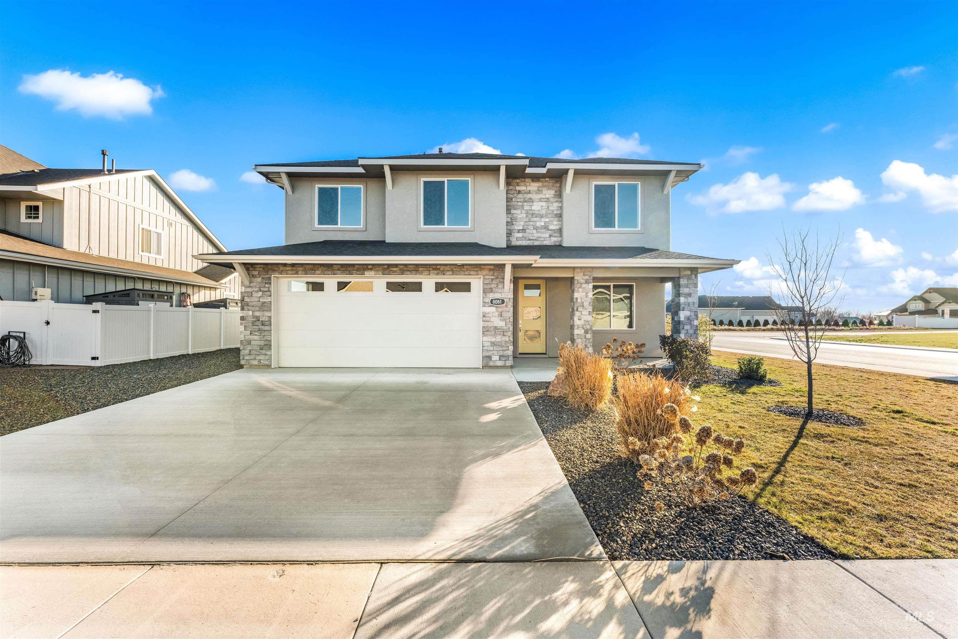 8081 Tandy Cove Street Middleton, ID 83644 - Photo 1 of 41 View of front of house featuring stucco siding, concrete driveway, a garage, stone siding, and a porch