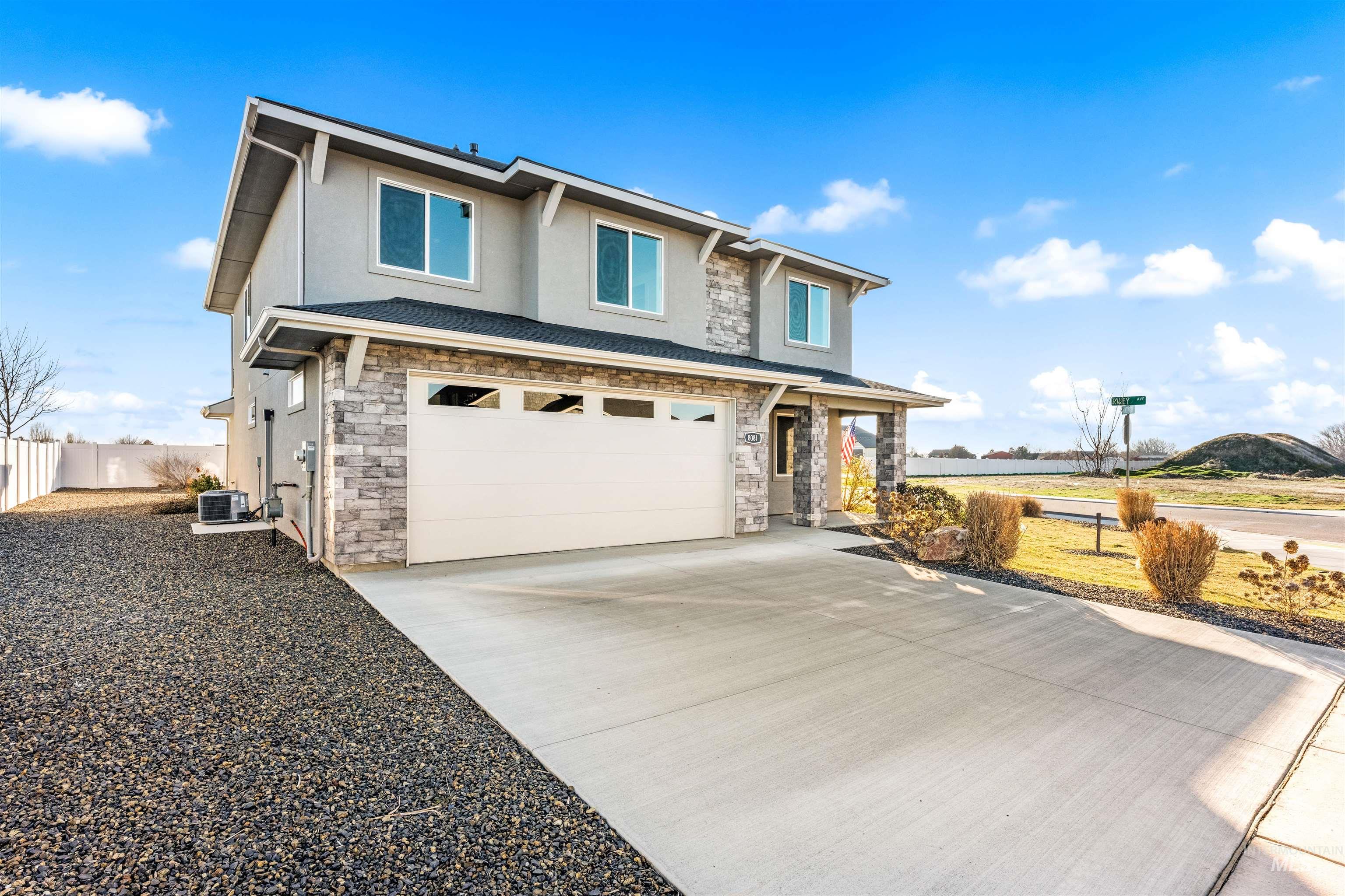 8081 Tandy Cove Street Middleton, ID 83644 - Photo 2 of 41 View of front of property featuring stone siding, stucco siding, an attached garage, and driveway