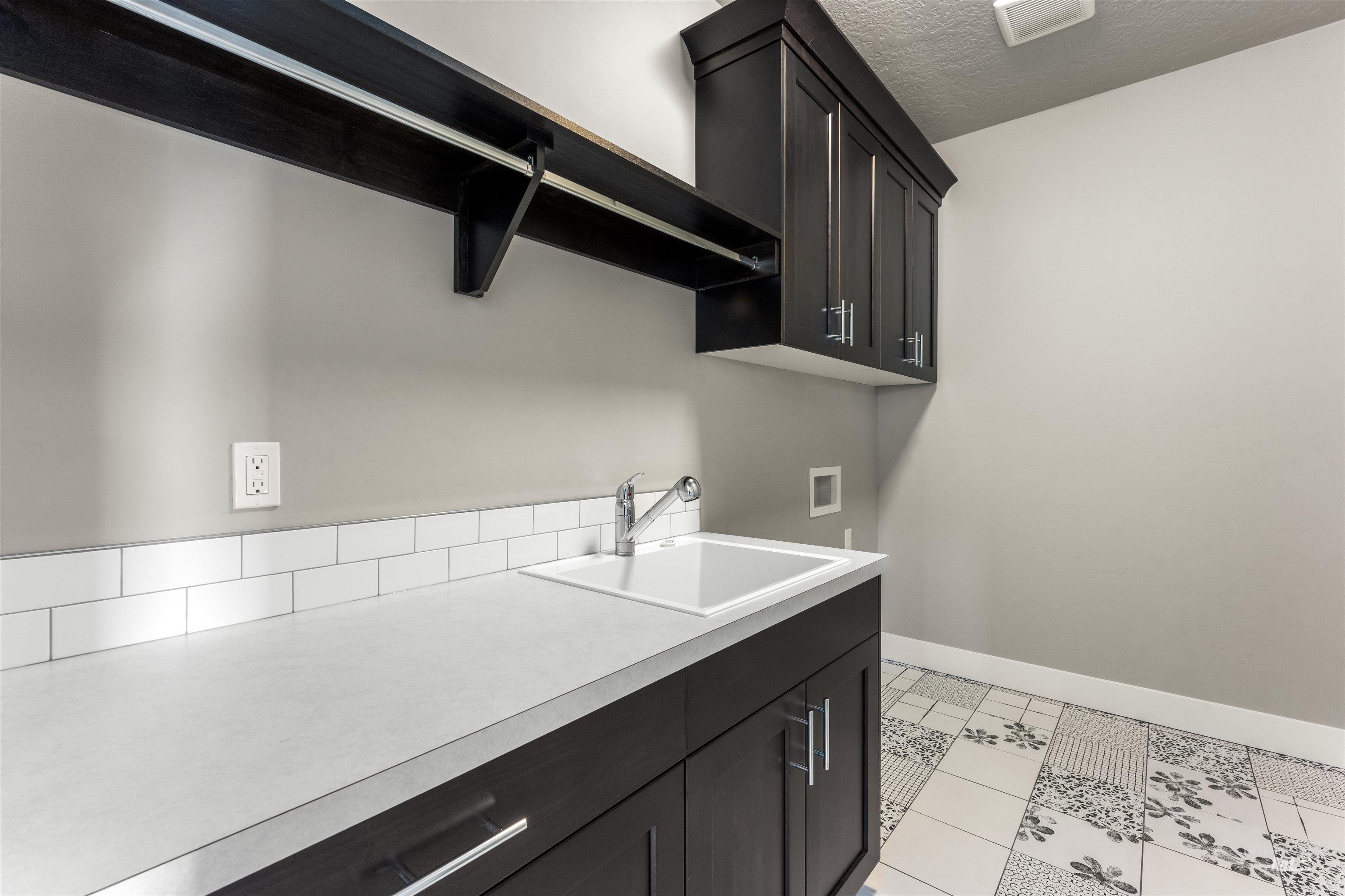 8081 Tandy Cove Street Middleton, ID 83644 - Photo 26 of 41 Laundry room featuring washer hookup, cabinet space, a textured ceiling, and light tile patterned floors