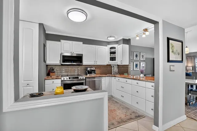 a kitchen with stainless steel appliances granite countertop a refrigerator and a stove top oven