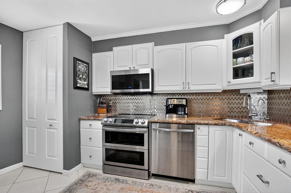 1537 East Hillsboro Boulevard, Unit 138 Deerfield Beach, FL 33441 - Photo 15 of 43 a kitchen with stainless steel appliances a stove microwave and cabinets
