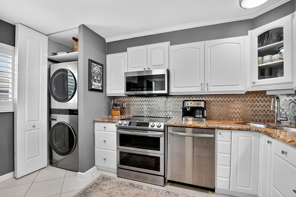 1537 East Hillsboro Boulevard, Unit 138 Deerfield Beach, FL 33441 - Photo 16 of 43 a kitchen with stainless steel appliances granite countertop a stove a washer and a microwave
