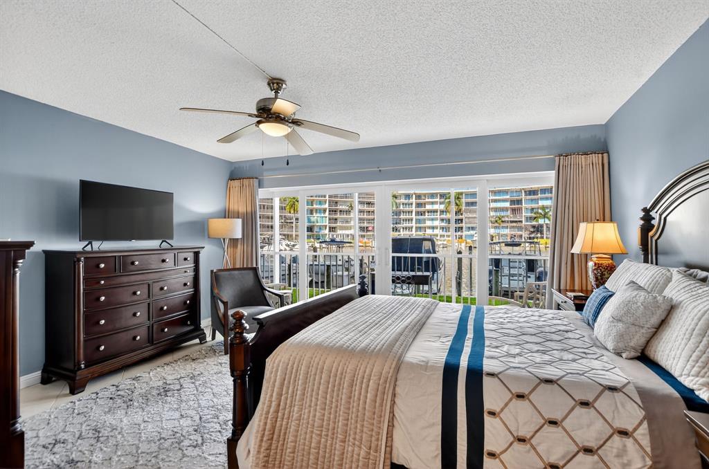 1537 East Hillsboro Boulevard, Unit 138 Deerfield Beach, FL 33441 - Photo 26 of 43 a bedroom with a bed and a flat tv screen on dresser