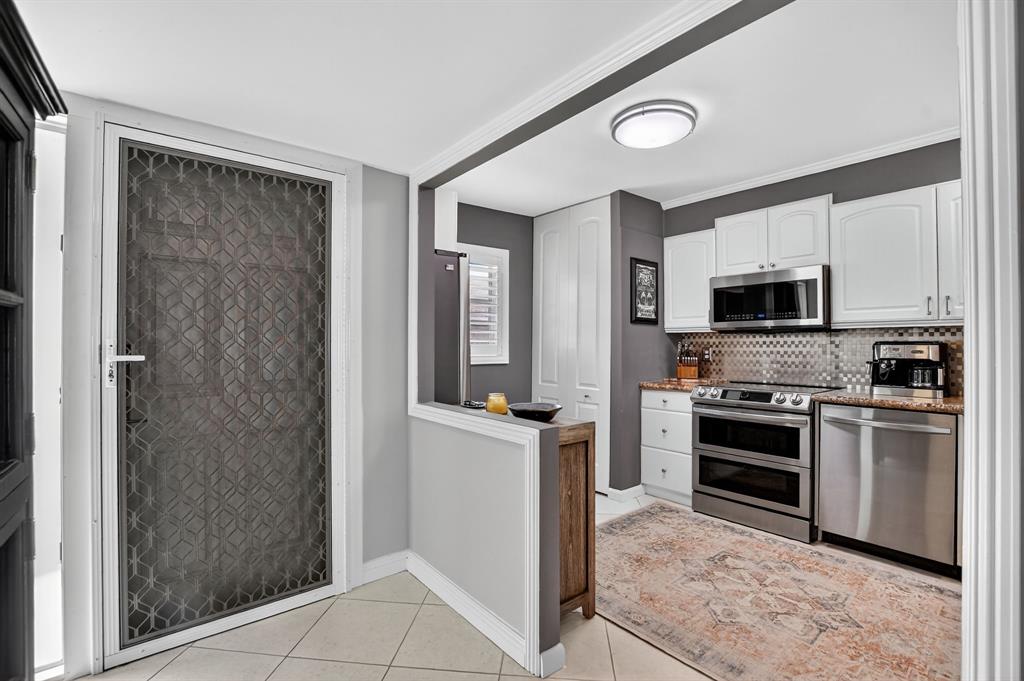 1537 East Hillsboro Boulevard, Unit 138 Deerfield Beach, FL 33441 - Photo 3 of 43 a kitchen with stainless steel appliances granite countertop a refrigerator oven a sink dishwasher a stove and a refrigerator with wooden floor