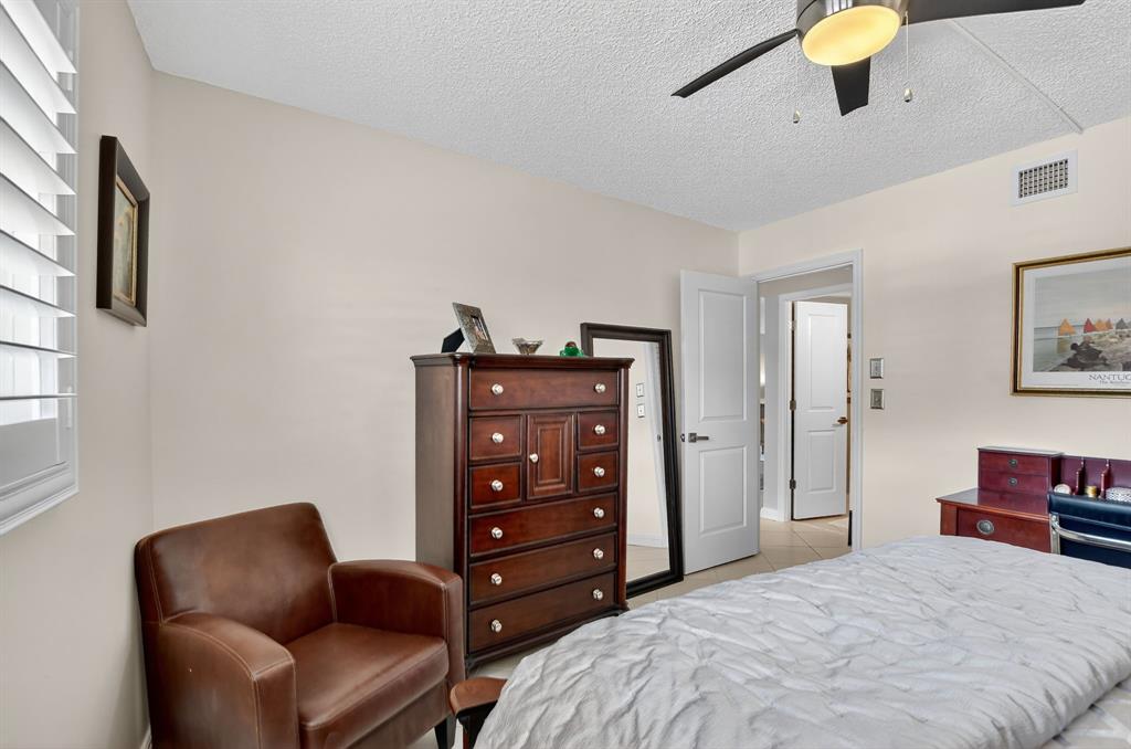 1537 East Hillsboro Boulevard, Unit 138 Deerfield Beach, FL 33441 - Photo 32 of 43 a bedroom with a bed a couch and a dresser