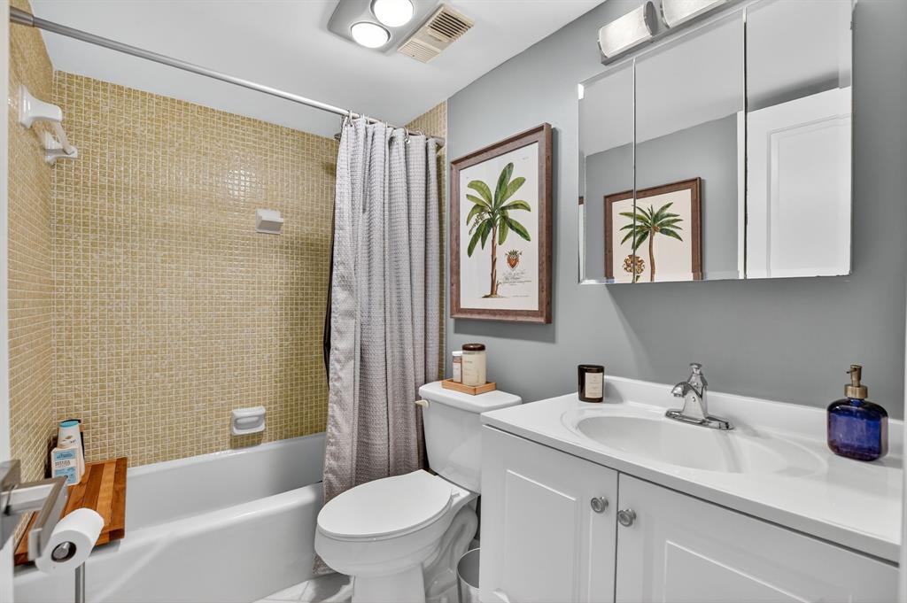 1537 East Hillsboro Boulevard, Unit 138 Deerfield Beach, FL 33441 - Photo 34 of 43 a bathroom with a sink a toilet a mirror a vanity and shower