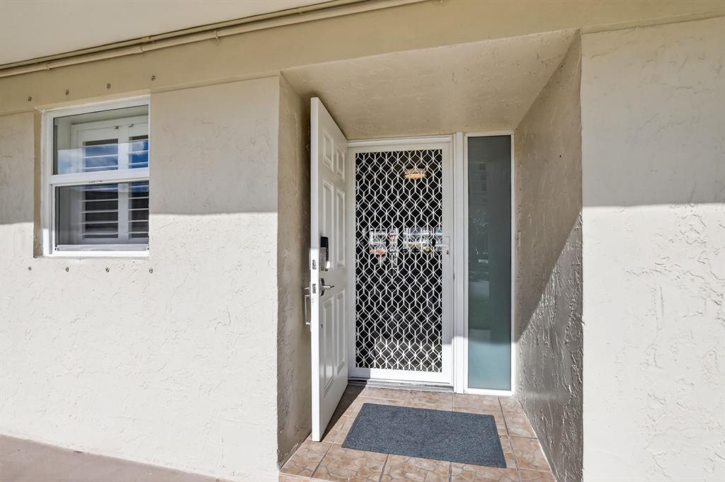 1537 East Hillsboro Boulevard, Unit 138 Deerfield Beach, FL 33441 - Photo 10 of 43 a view of a hallway with wooden floor and a dining room