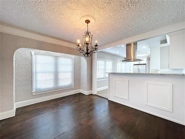 a view of a kitchen with wooden floor and a window