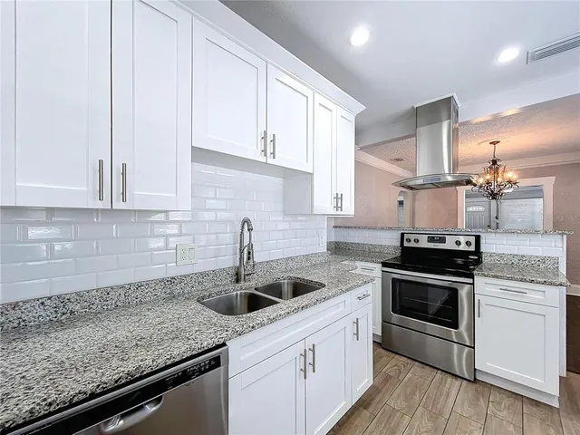 a kitchen with stainless steel appliances granite countertop a sink stove and cabinets