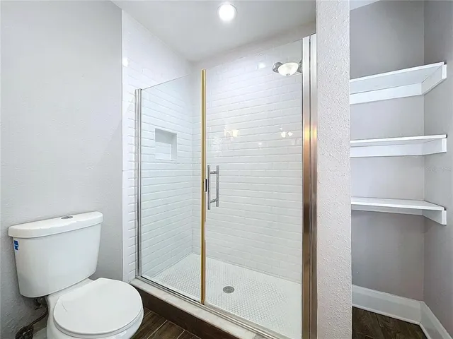 a white toilet next to a bathroom