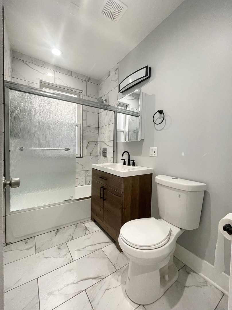 4435 West Thomas Street, Unit 1 Chicago, IL 60651 - Photo 5 of 11 a bathroom with a toilet sink and mirror