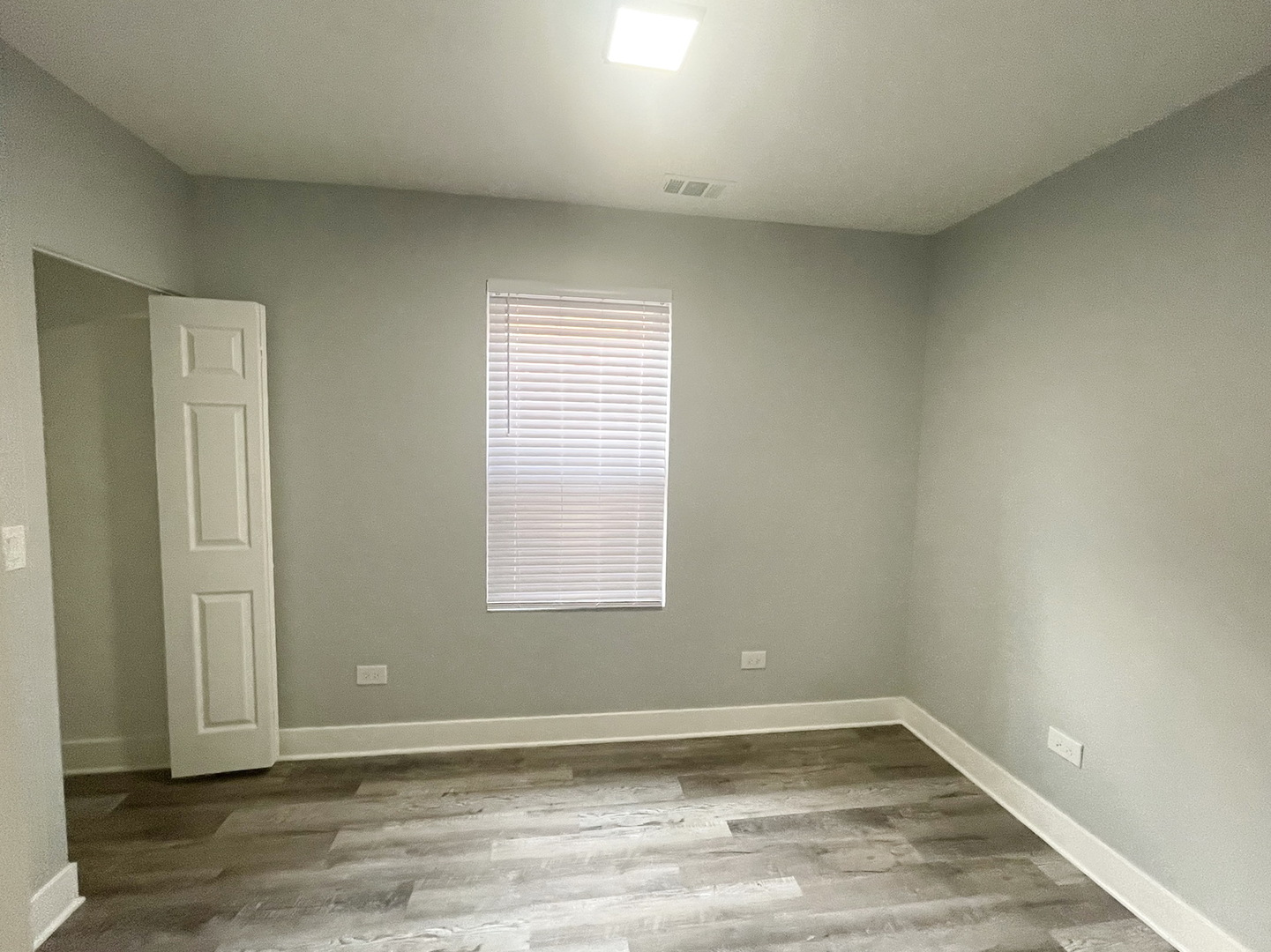 4435 West Thomas Street, Unit 1 Chicago, IL 60651 - Photo 7 of 11 an empty room with wooden floor and windows