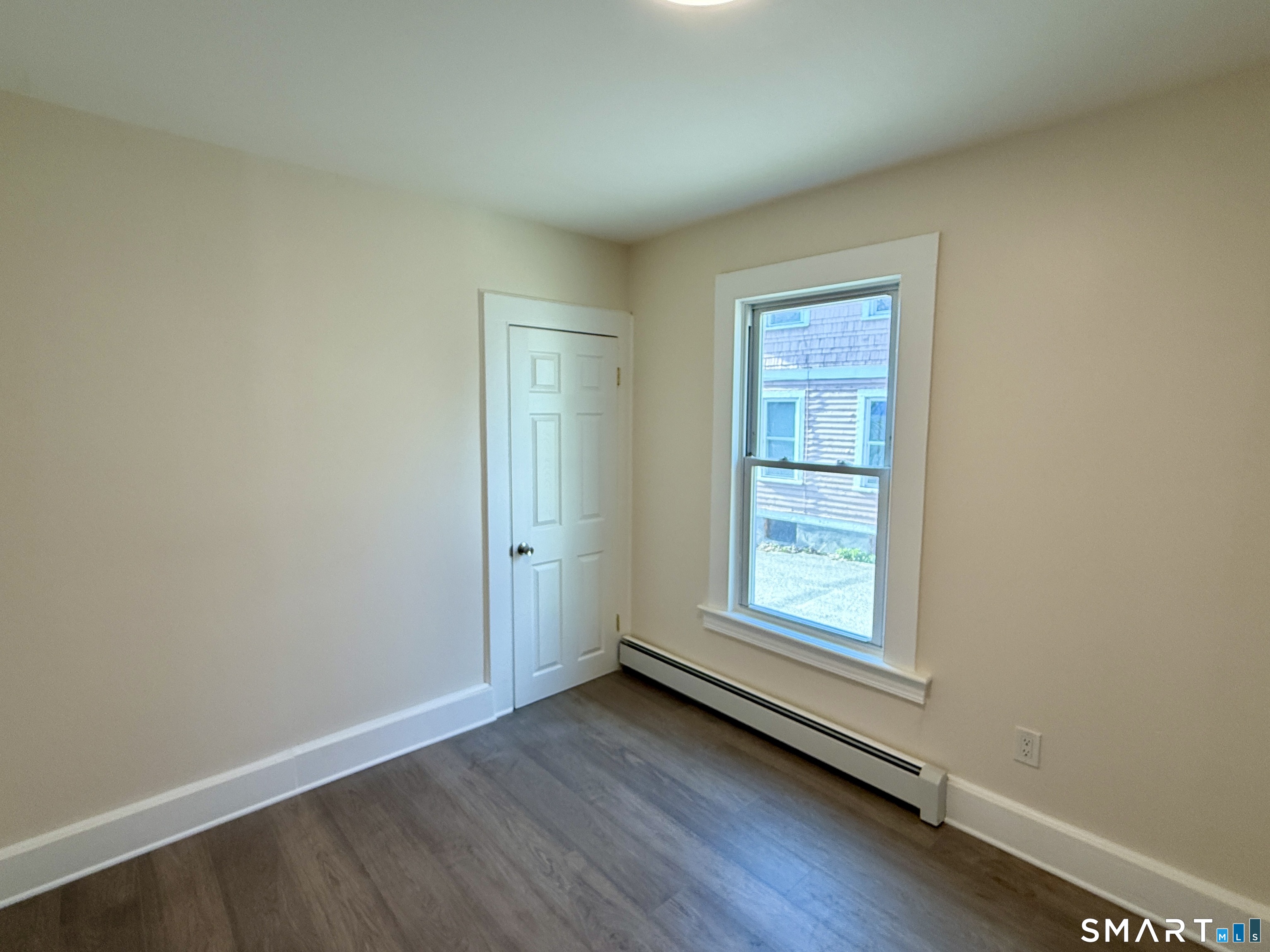 690 Main Street, Unit 1 Torrington, CT 06790 - Photo 9 of 12 an empty room with wooden floor and windows