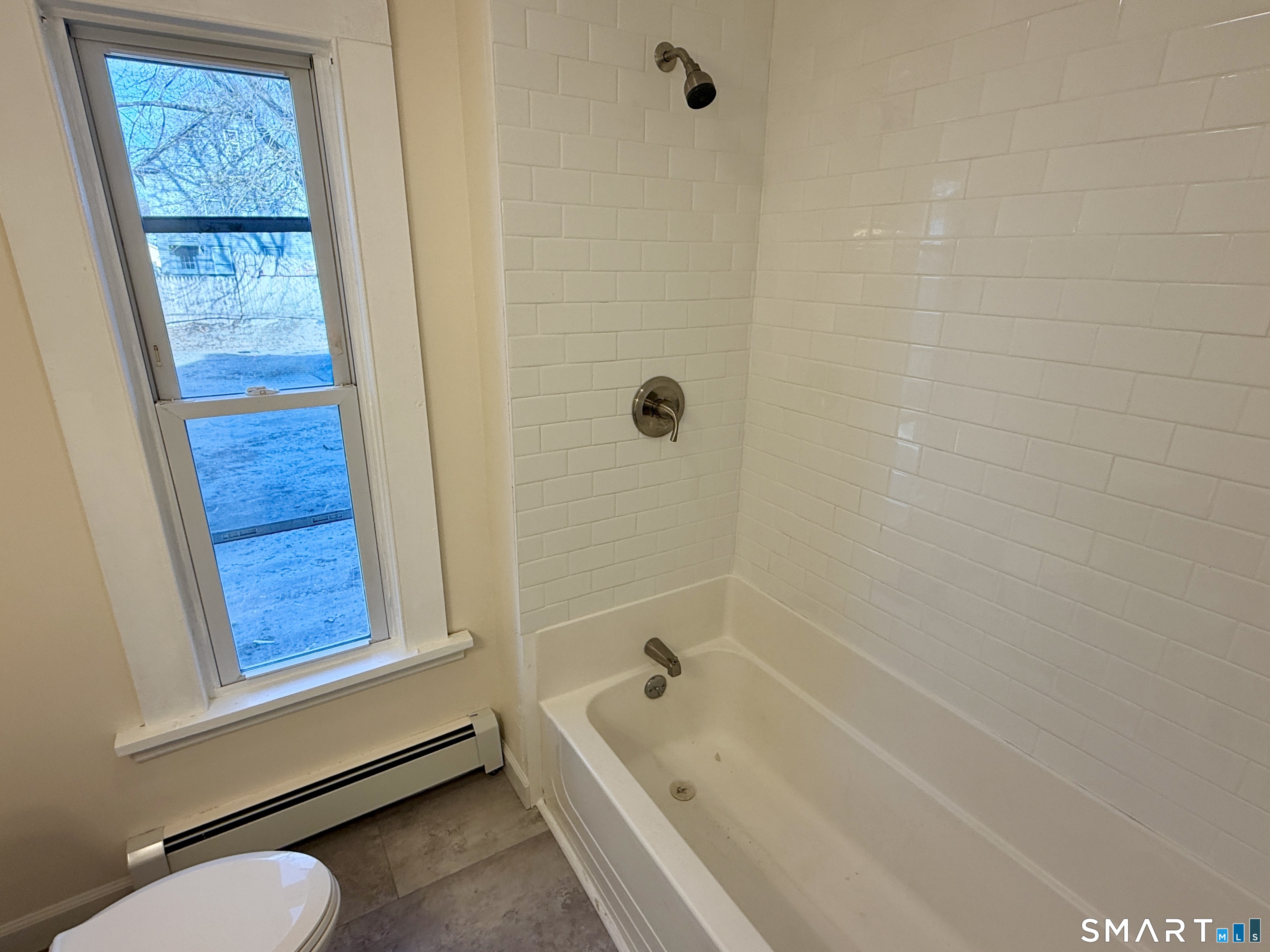 690 Main Street, Unit 1 Torrington, CT 06790 - Photo 10 of 12 a bathroom with a tub a window and a shower