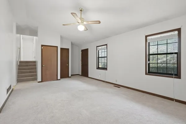 an empty room with windows and closet