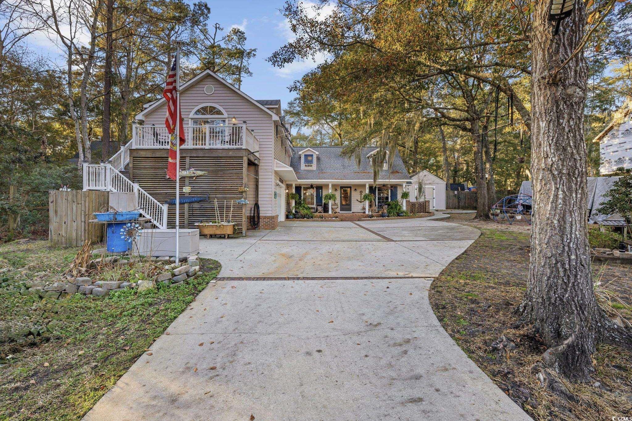 View of front of house with driveway, stairs, and brick siding