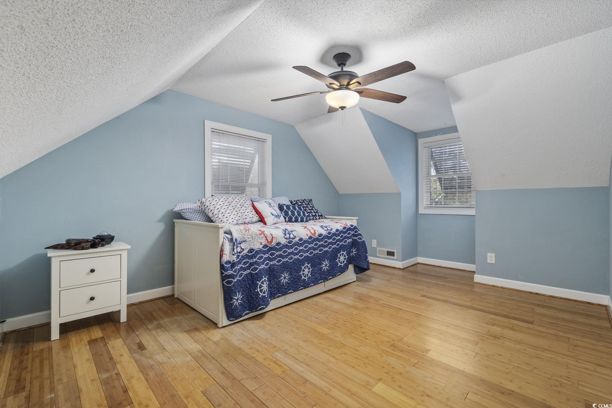 153 Watson Way Pawleys Island, SC 29585 - Photo 11 of 40 Bedroom with a textured ceiling, light wood-type flooring, ceiling fan, and lofted ceiling