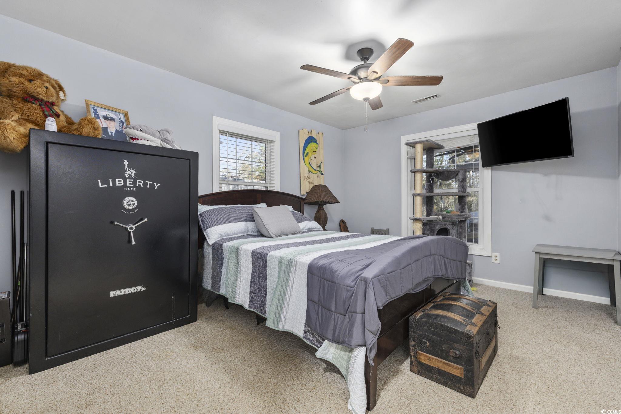 153 Watson Way Pawleys Island, SC 29585 - Photo 22 of 40 Bedroom with light carpet, multiple windows, and a ceiling fan